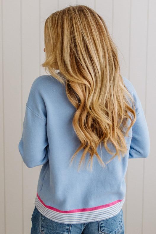 Person wearing a light blue sweater with a white background