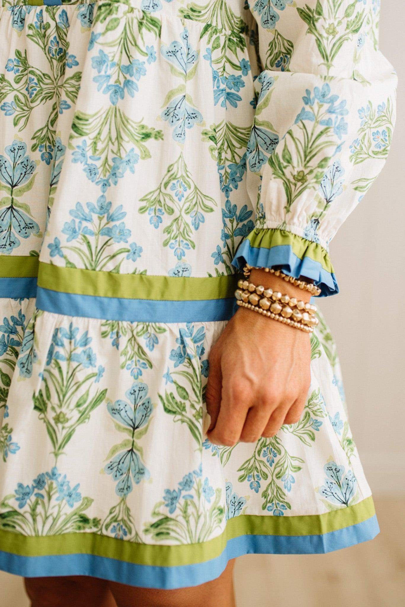 Close-up of a person wearing a floral dress with green and blue accents.