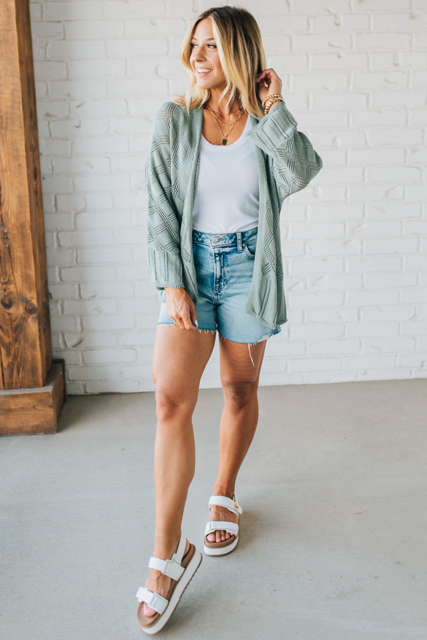 Blonde Model Wearing A Lightweight Crochet Cardigan With Scallop Hem.