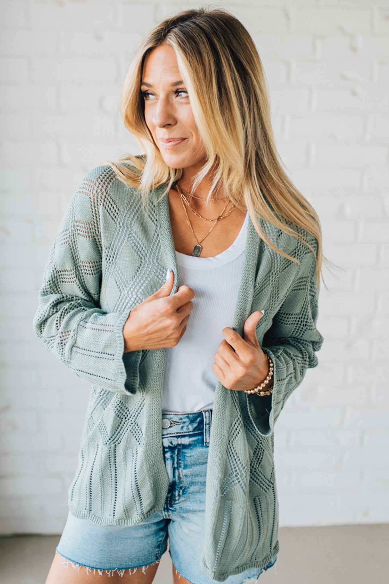 Blonde Model Wearing A Lightweight Crochet Cardigan With Scallop Hem.