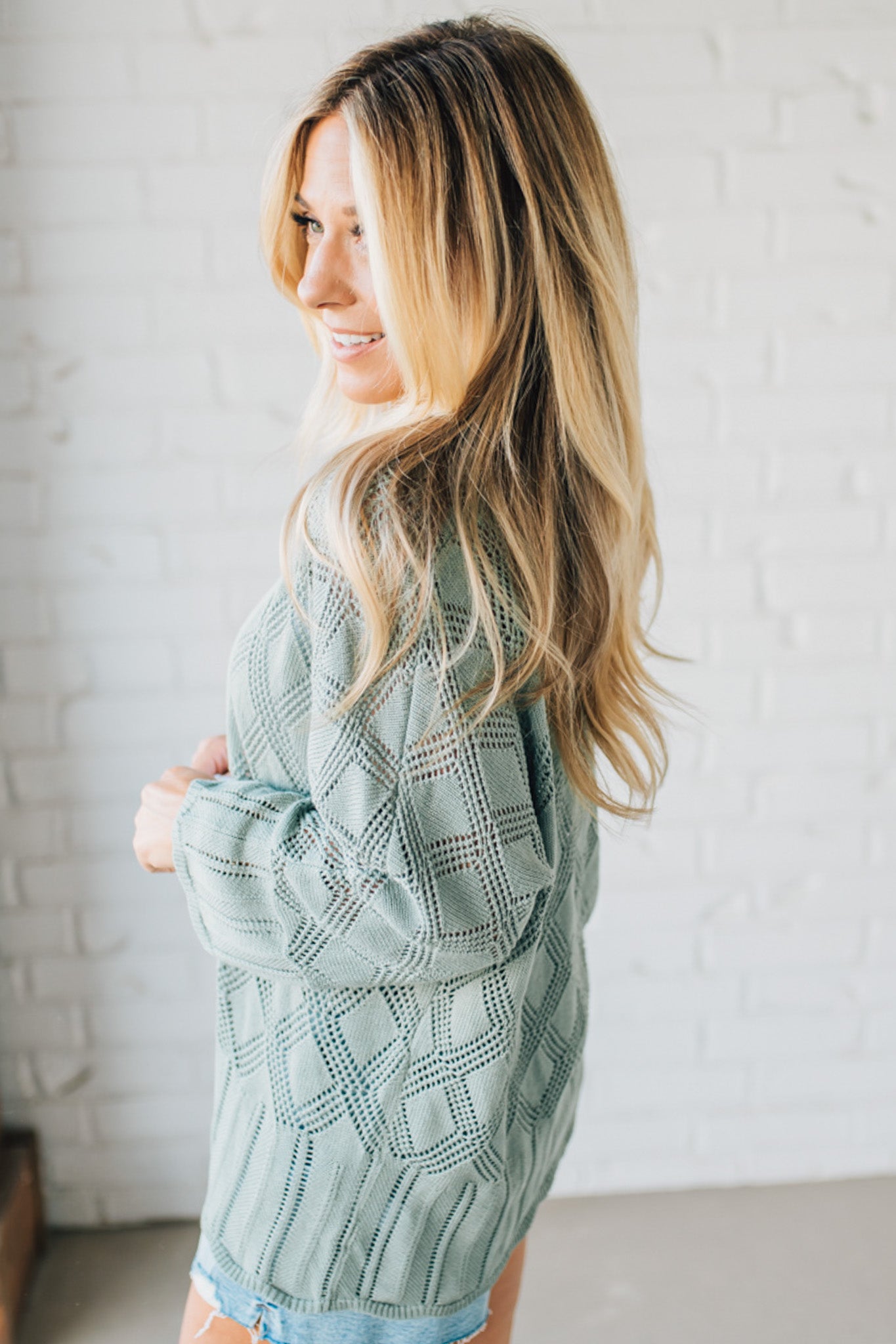 Blonde Model Wearing A Lightweight Crochet Cardigan With Scallop Hem.