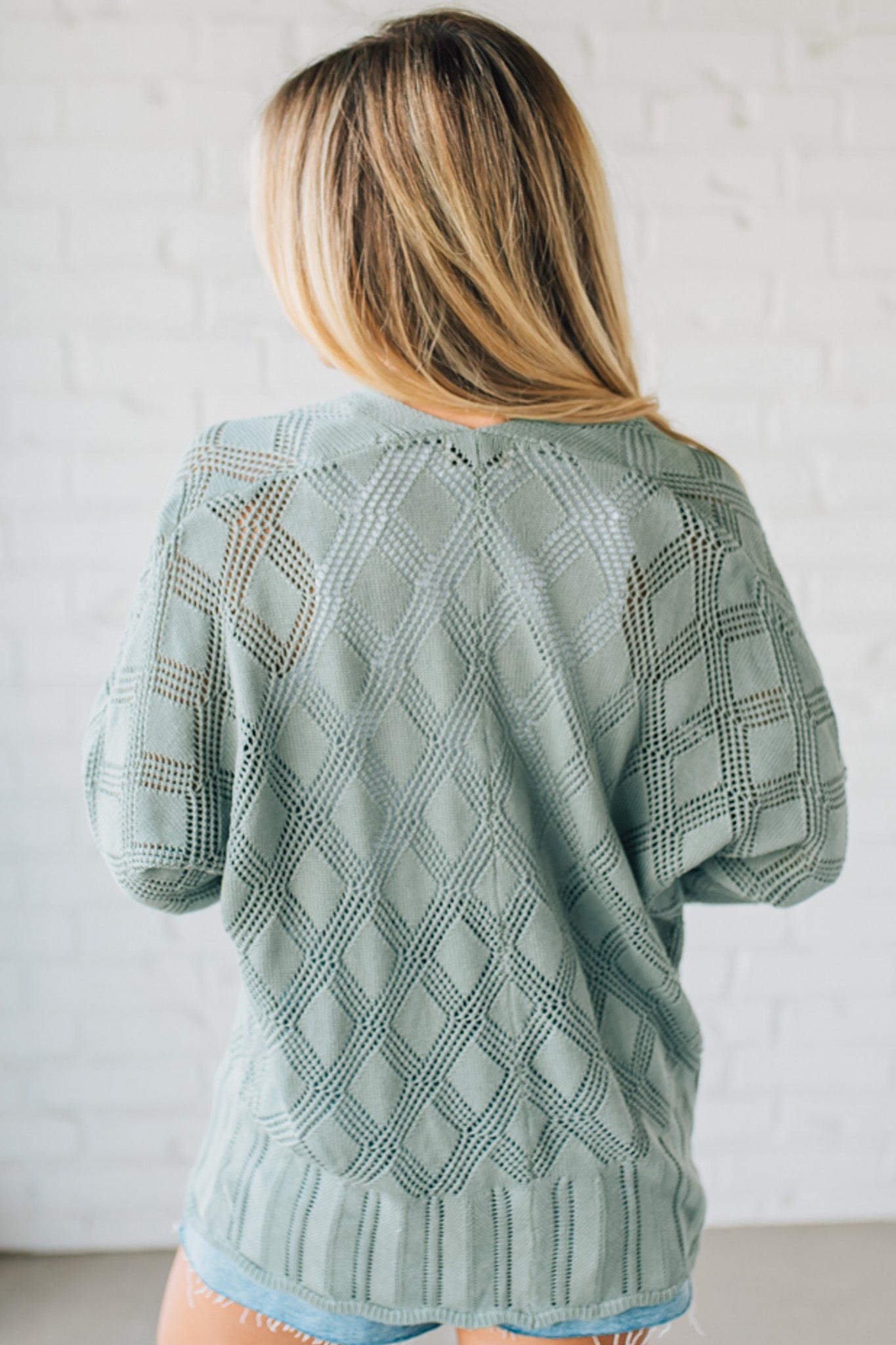 Blonde Model Wearing A Lightweight Crochet Cardigan With Scallop Hem.