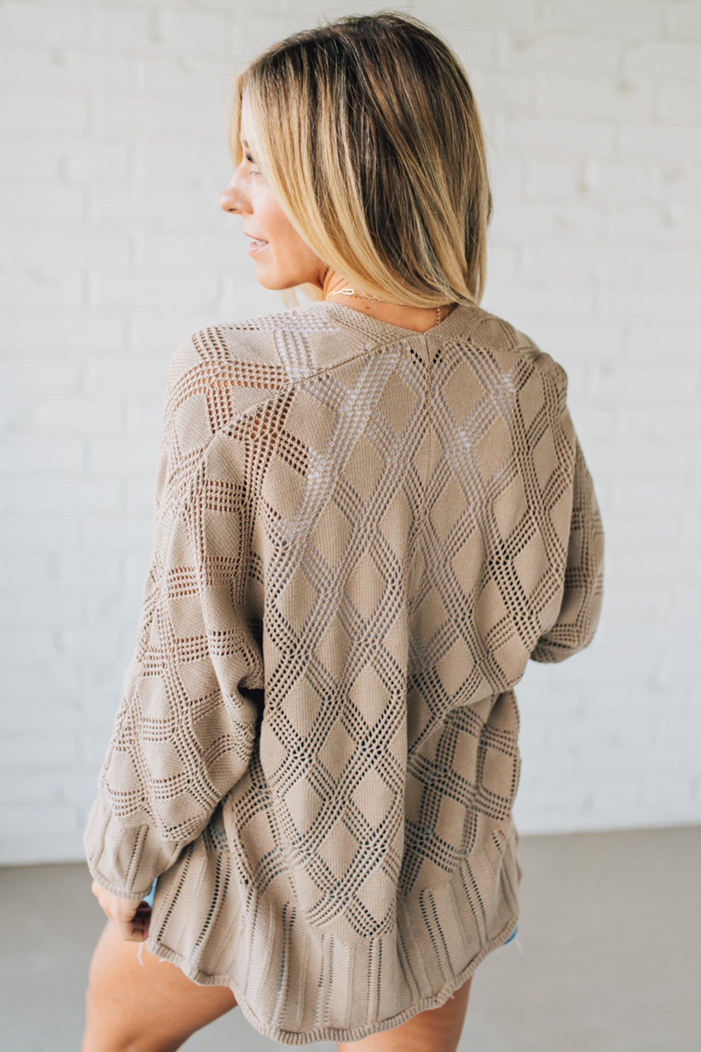 Blonde Model Wearing A Lightweight Crochet Cardigan With Scallop Hem.