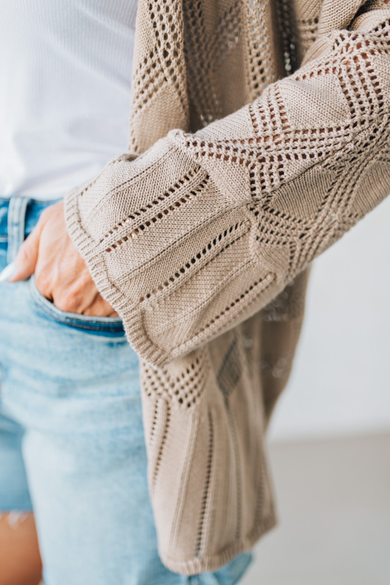 Blonde Model Wearing A Lightweight Crochet Cardigan With Scallop Hem.
