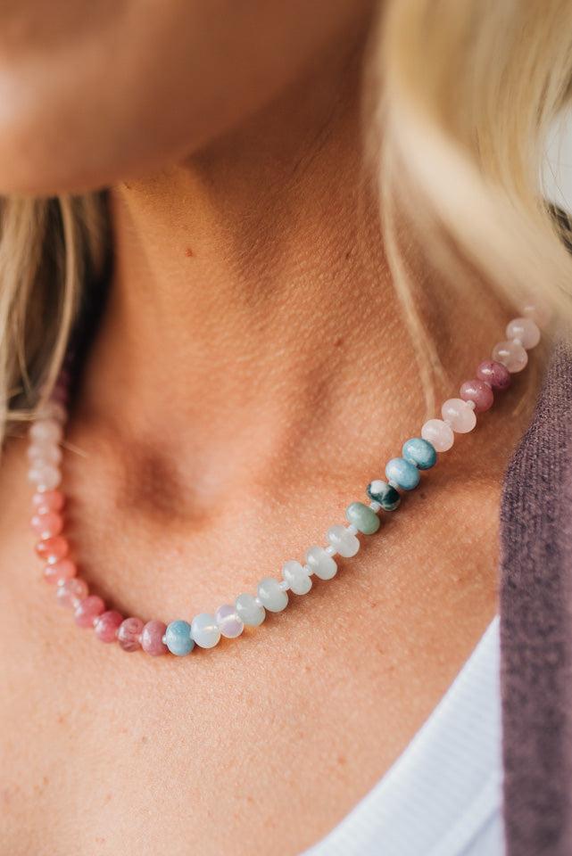 Close-up of a woman wearing a colorful beaded necklace.