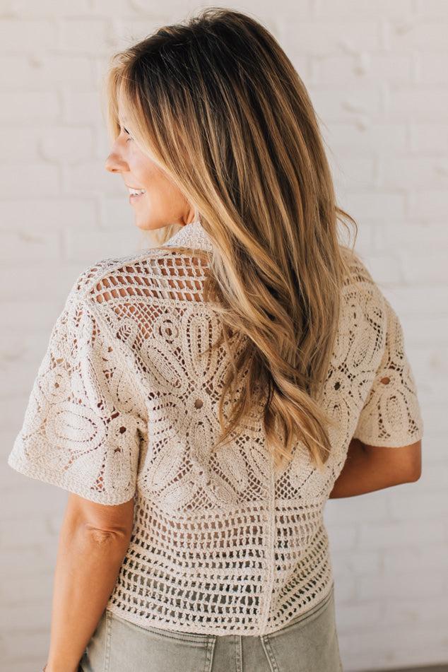 BLONDE WOMAN WEARING A SHORT SLEEVE CROCHET SWEATER CROP CARDIGAN.