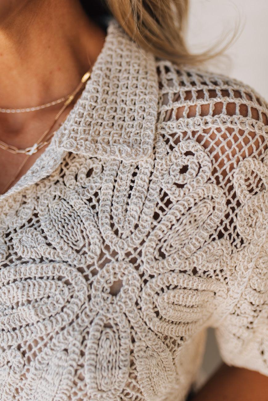 BLONDE WOMAN WEARING A SHORT SLEEVE CROCHET SWEATER CROP CARDIGAN.