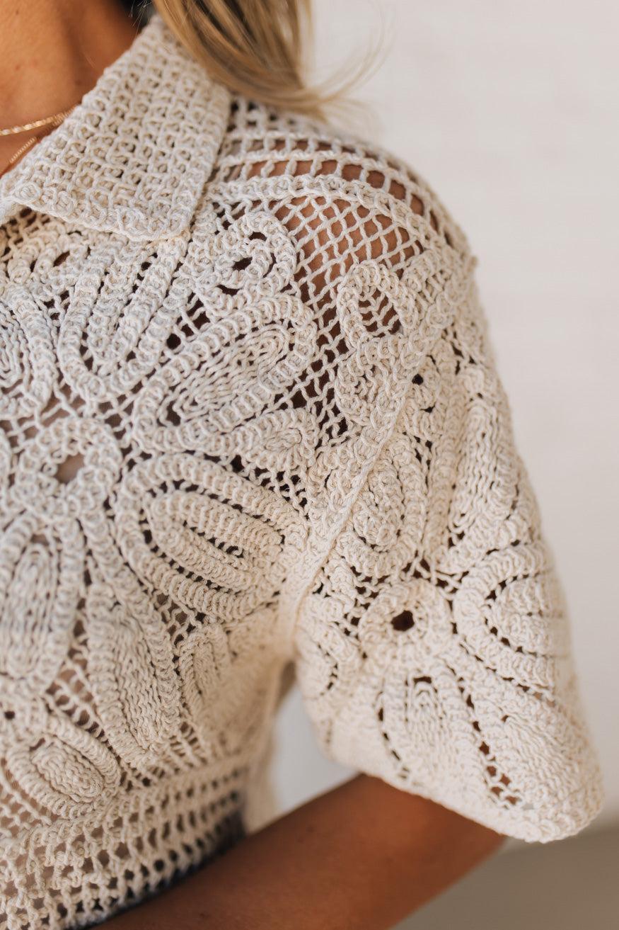 BLONDE WOMAN WEARING A SHORT SLEEVE CROCHET SWEATER CROP CARDIGAN.