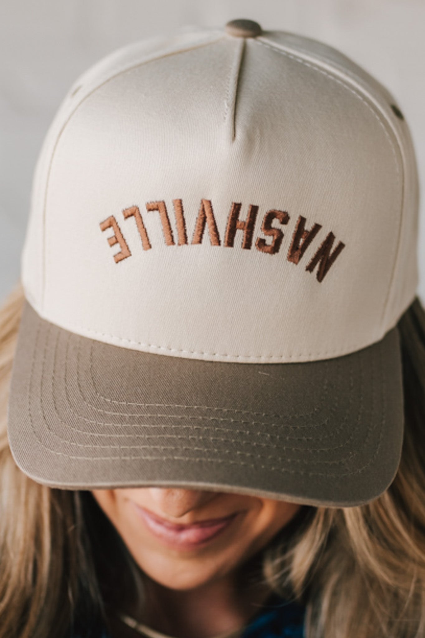 Two tone trucker hat cream and mocha with upside down NASHVILLE embroidery.