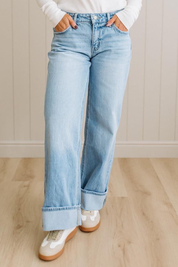 Person wearing light blue jeans with a neutral background