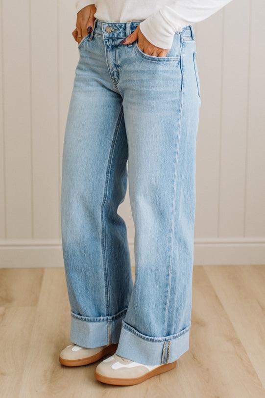 Person wearing light blue jeans with a white background