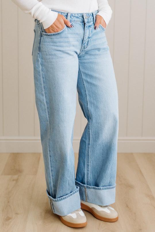 Person wearing light blue jeans with a neutral background
