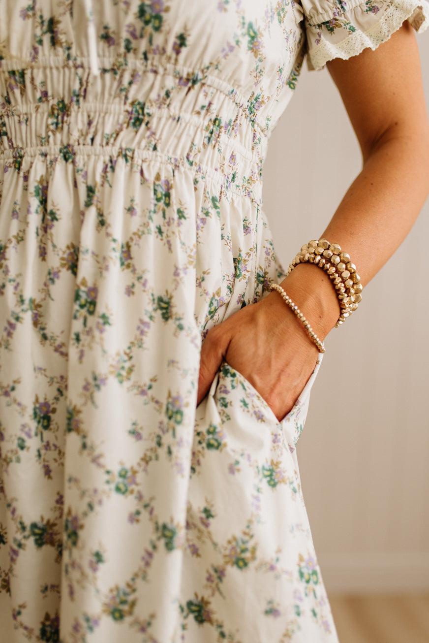 Close-up of a person wearing a floral dress with a neutral background