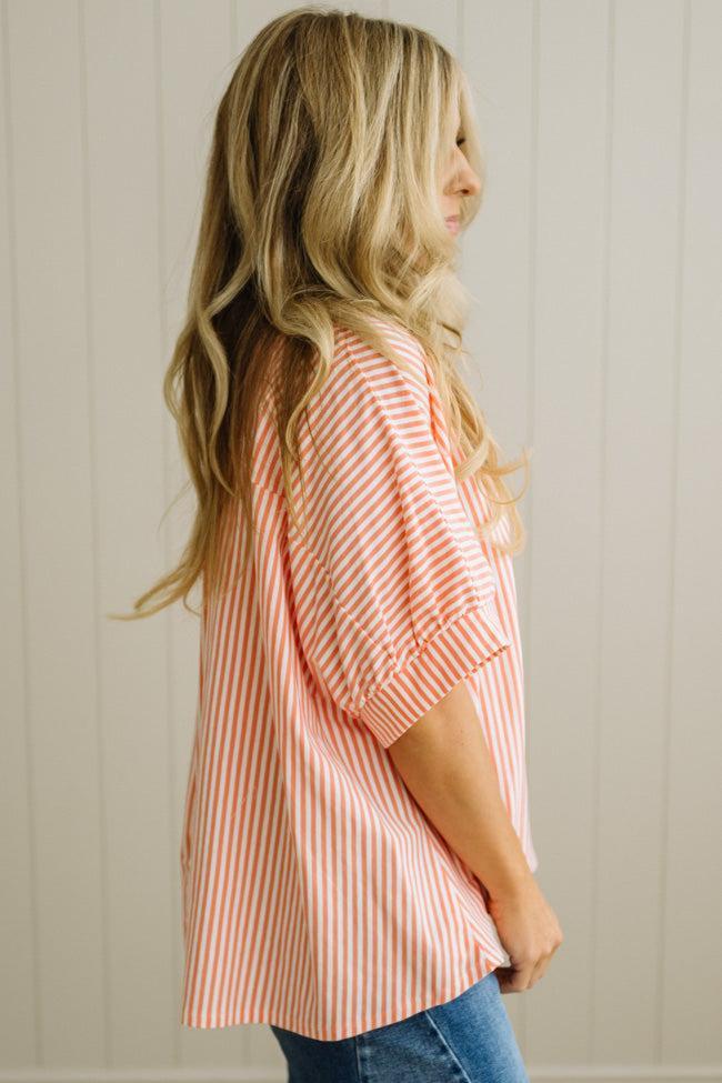Woman wearing a red and white striped shirt against a neutral background