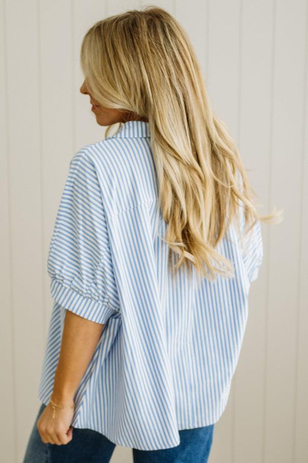 Woman wearing a blue and white striped shirt against a neutral background