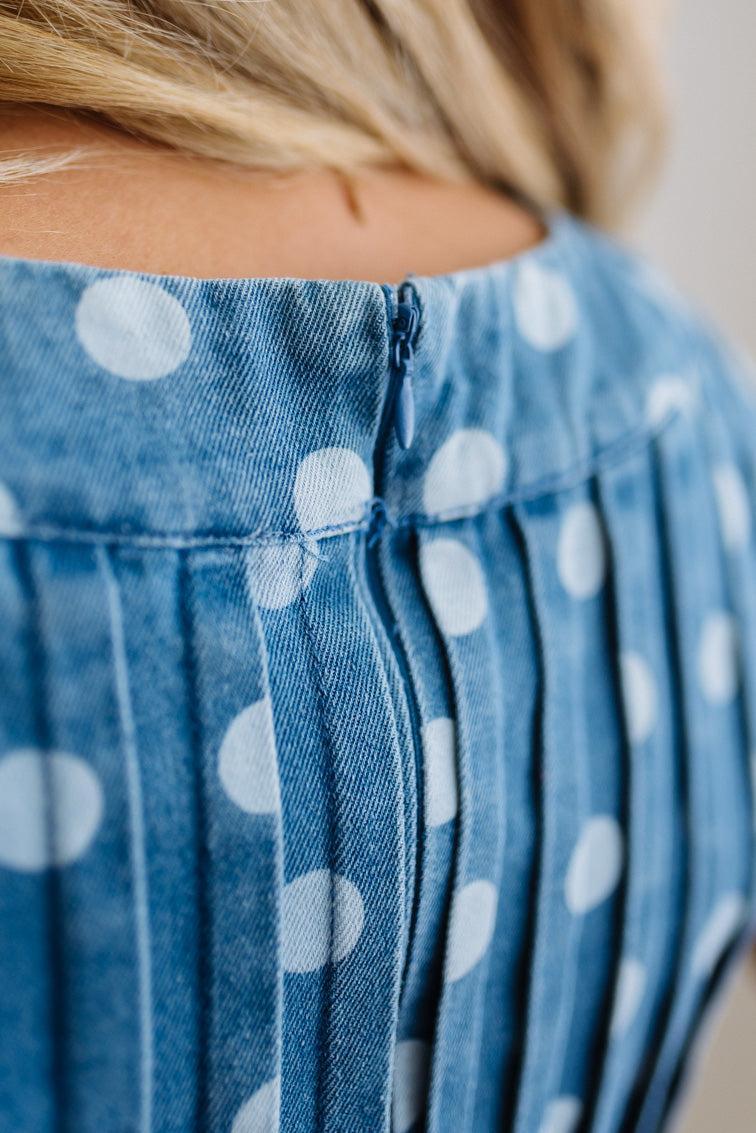 Close-up of a blue polka dot romper with a blurred background
