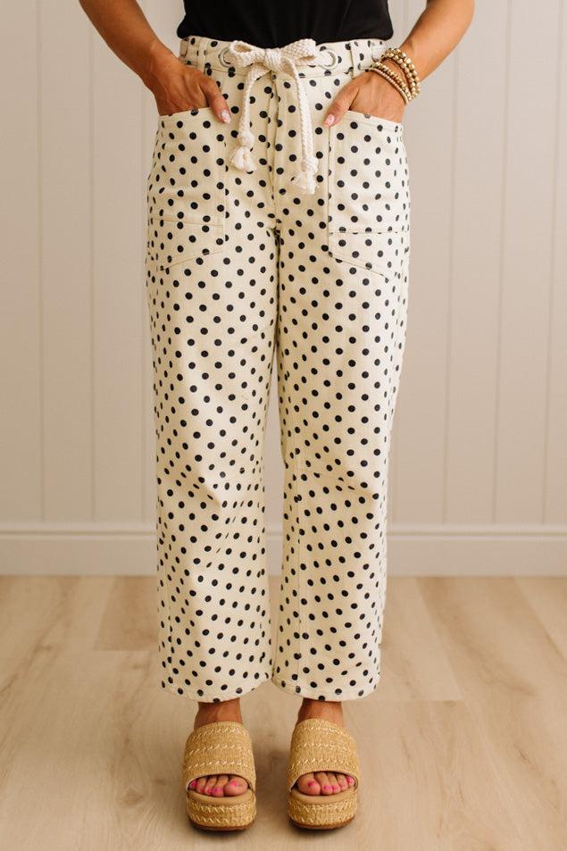 Person wearing polka dot pants with a neutral background