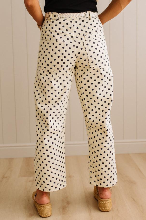 Person wearing polka dot pants with a neutral background
