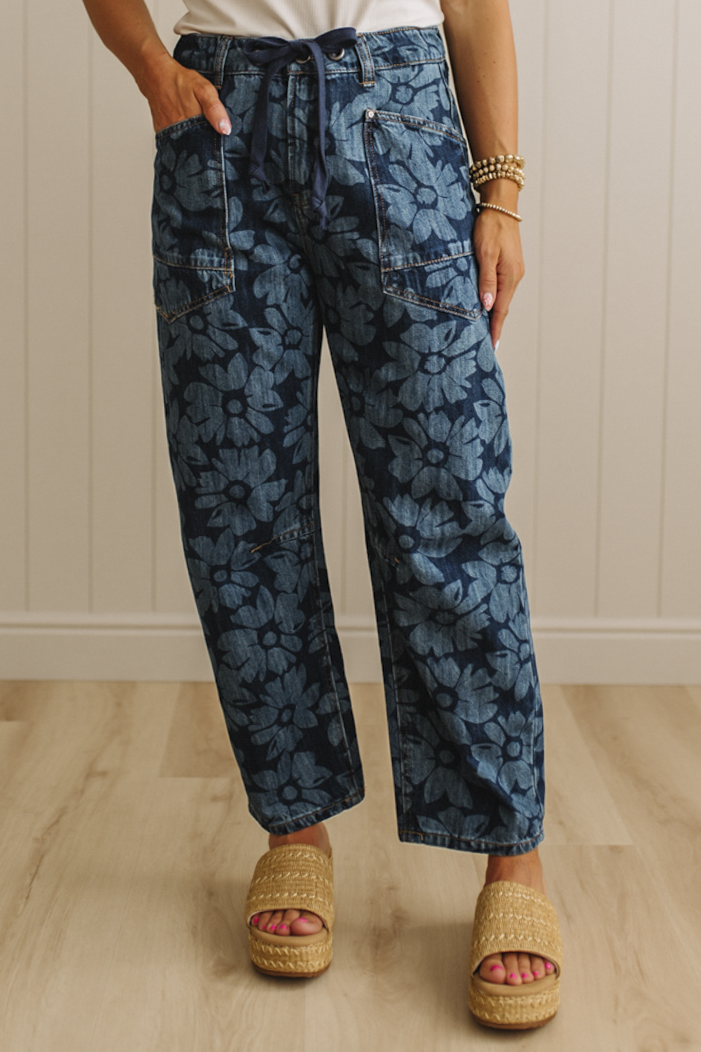 Person wearing blue floral-patterned pants with a neutral background