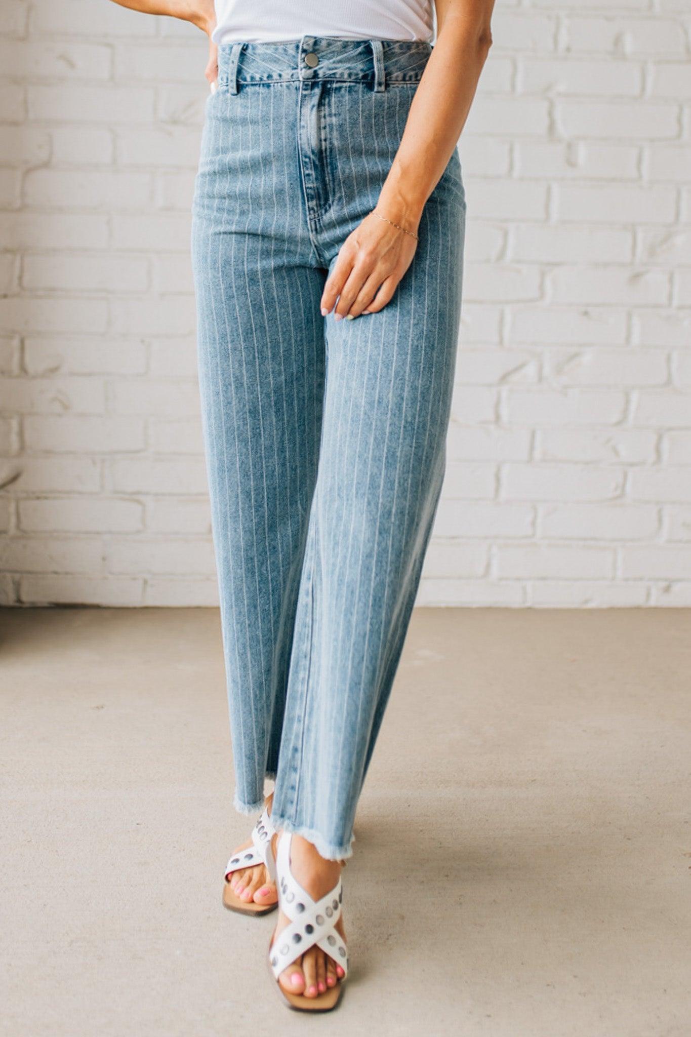 WOMAN WEARING WASHED STRIPE DENIM FRAYED HEM PANTS.