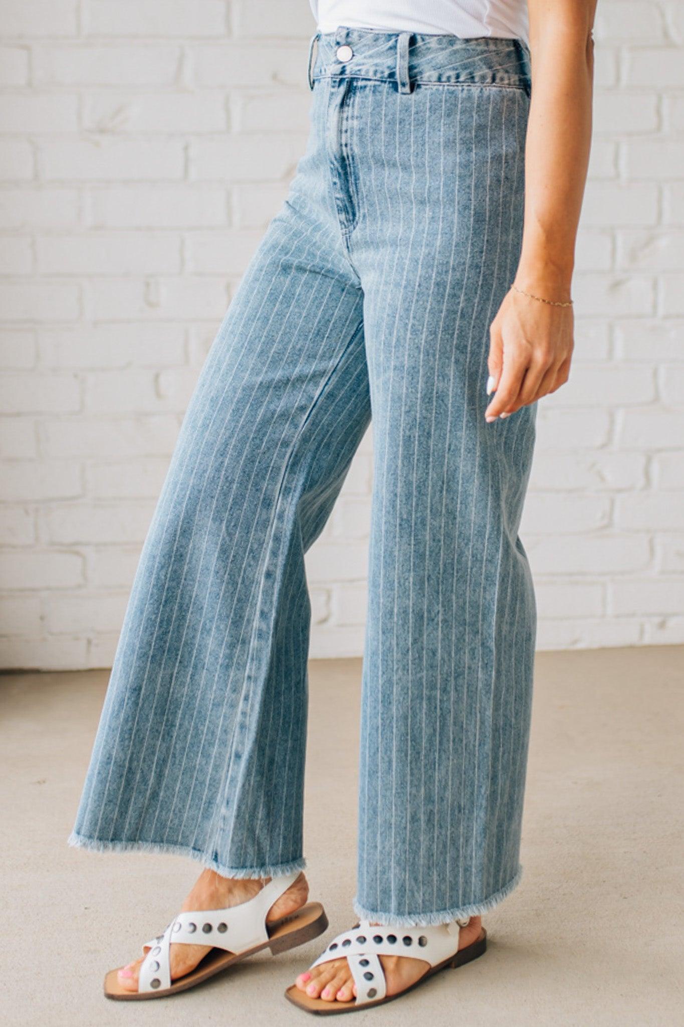 WOMAN WEARING WASHED STRIPE DENIM FRAYED HEM PANTS.
