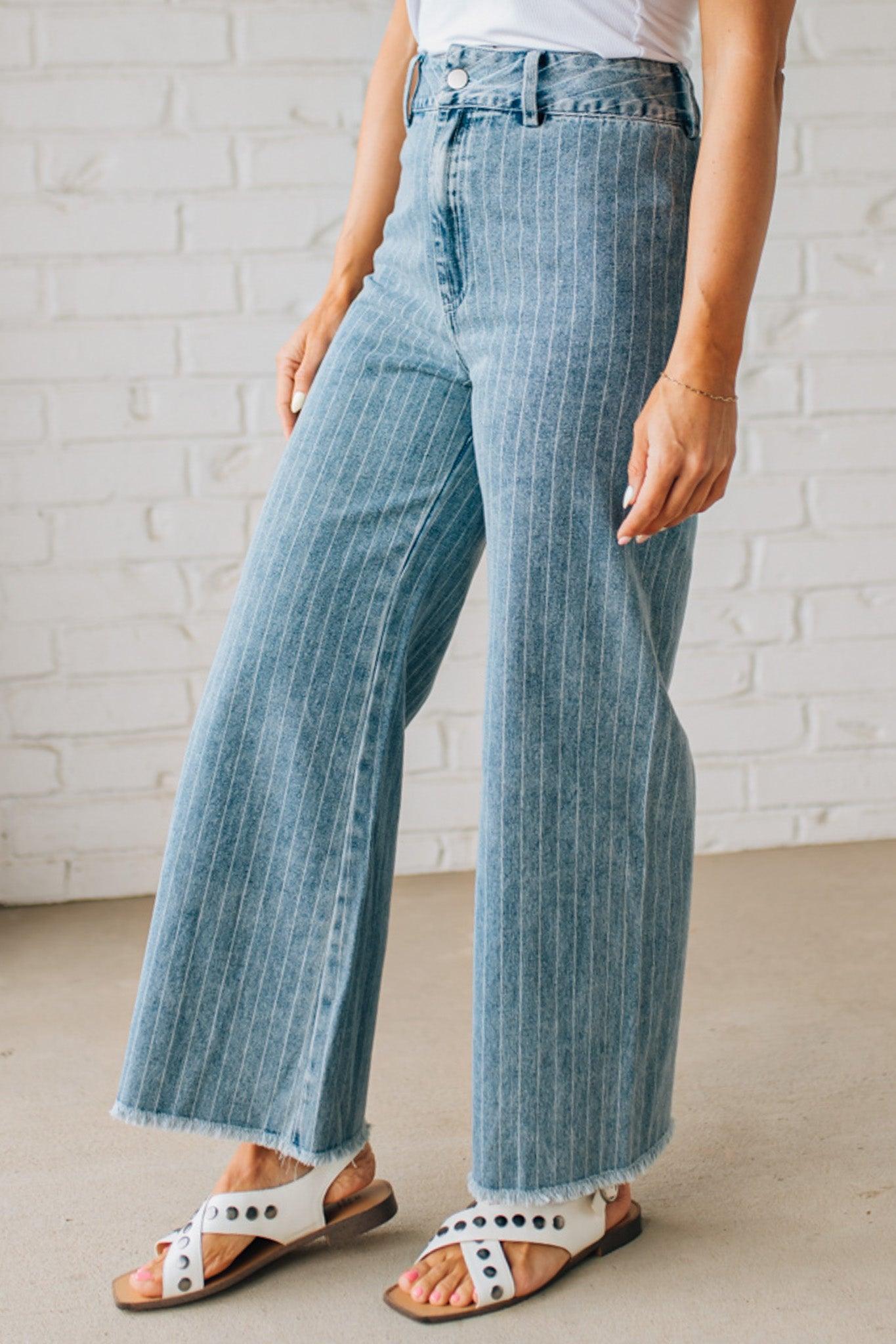WOMAN WEARING WASHED STRIPE DENIM FRAYED HEM PANTS.