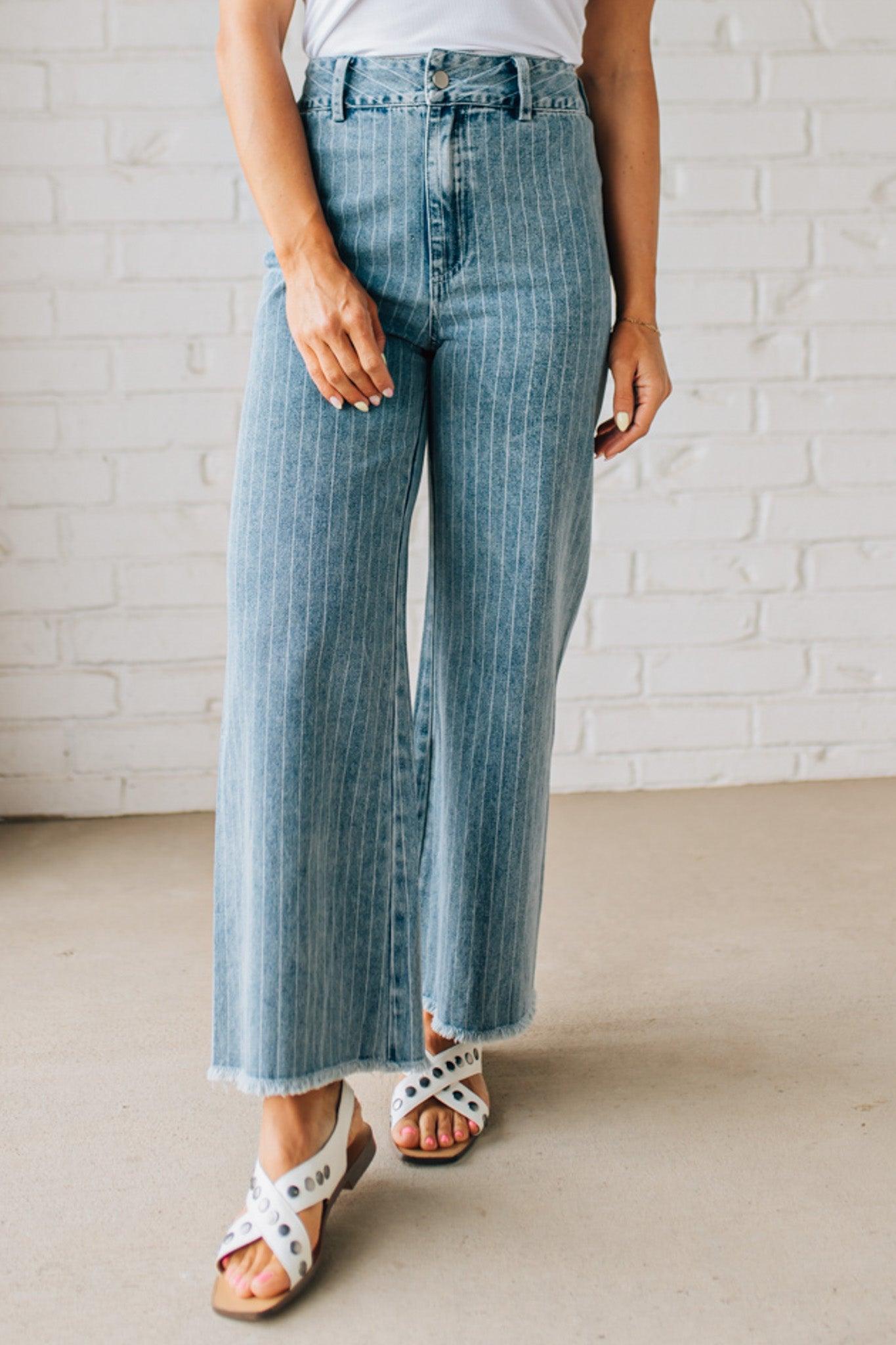 WOMAN WEARING WASHED STRIPE DENIM FRAYED HEM PANTS.