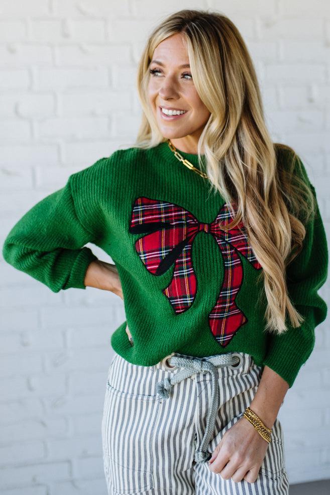 BLONDE WOMAN WEARING CHECKERED PLAID BIG RIBBON CHRISTMAS HOLIDAY LOOSE FIT SWEATER PULL OVER TOP