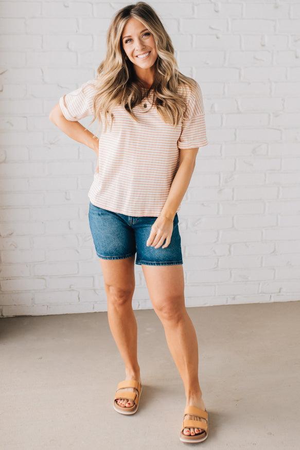 BLONDE WOMAN WEARING A COLOR TRIMMED ROUND NECK, ROLL UP SHORT SLEEVE, POINTELLE STRIPE TOP.