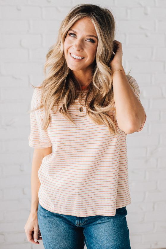BLONDE WOMAN WEARING A COLOR TRIMMED ROUND NECK, ROLL UP SHORT SLEEVE, POINTELLE STRIPE TOP.