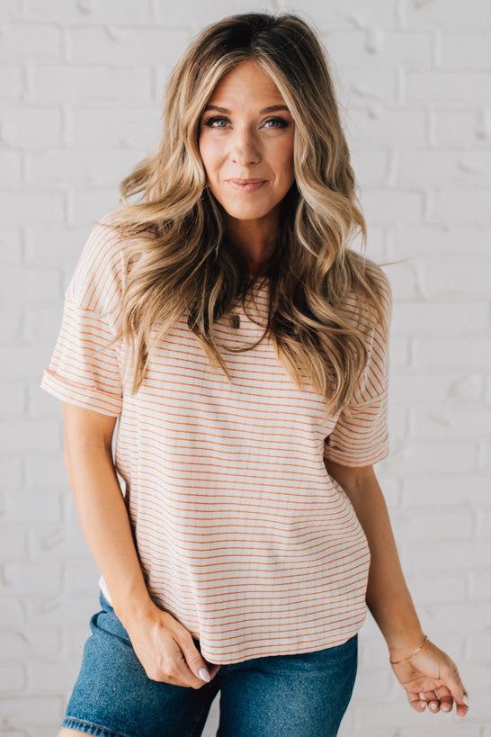 BLONDE WOMAN WEARING A COLOR TRIMMED ROUND NECK, ROLL UP SHORT SLEEVE, POINTELLE STRIPE TOP.