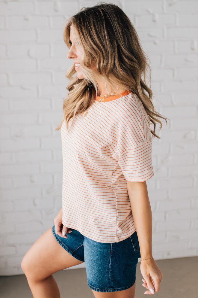 BLONDE WOMAN WEARING A COLOR TRIMMED ROUND NECK, ROLL UP SHORT SLEEVE, POINTELLE STRIPE TOP.
