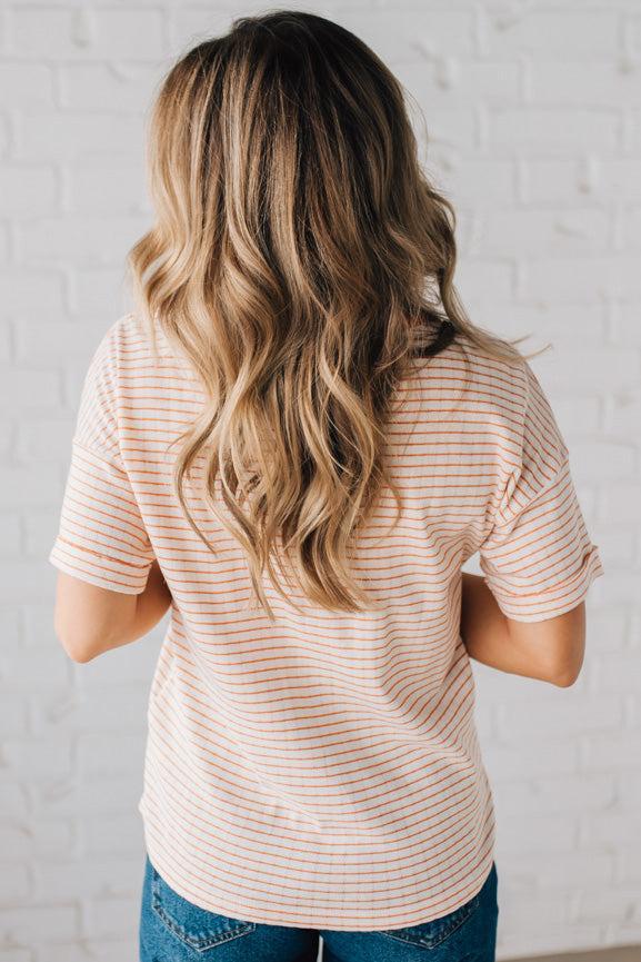 BLONDE WOMAN WEARING A COLOR TRIMMED ROUND NECK, ROLL UP SHORT SLEEVE, POINTELLE STRIPE TOP.
