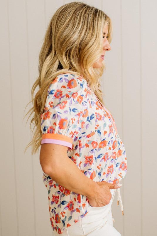 Woman wearing a floral blouse against a neutral background