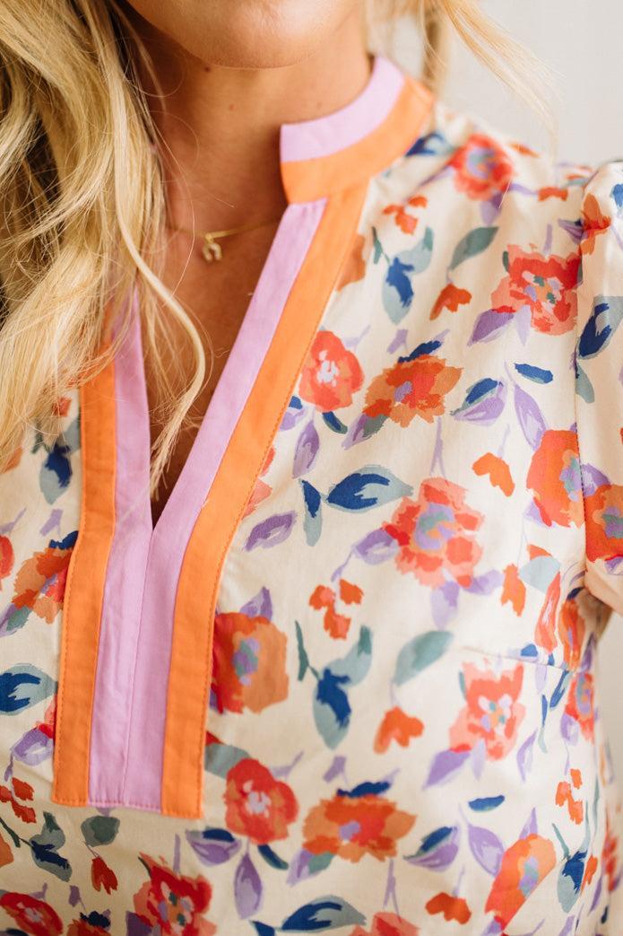 Close-up of a colorful floral jacket with orange and pink accents.