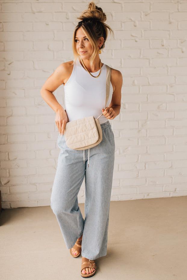 Blonde woman wearing a Foldover Quilted Crossbody bag in stone color.