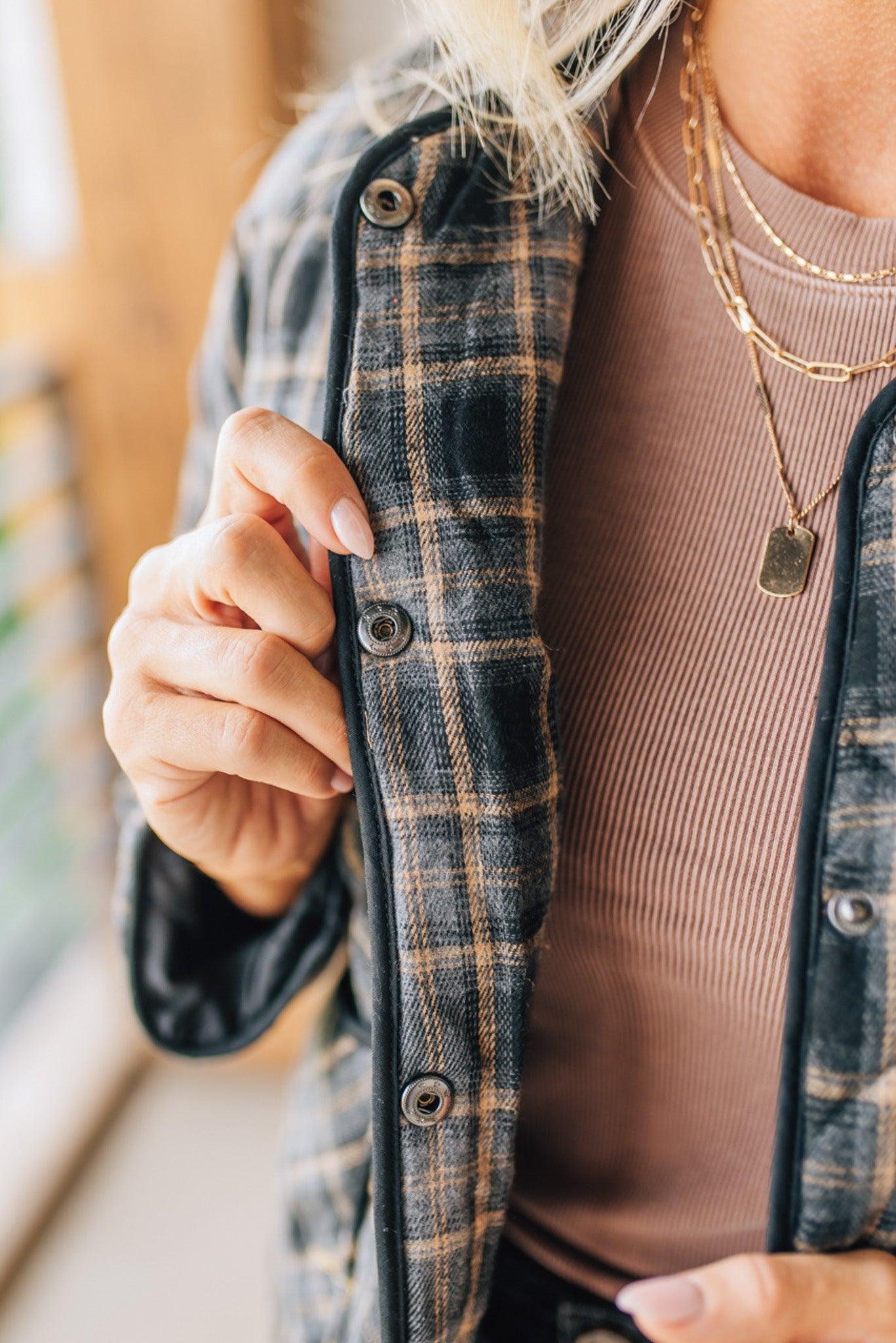 Person wearing a plaid jacket with a blurred background