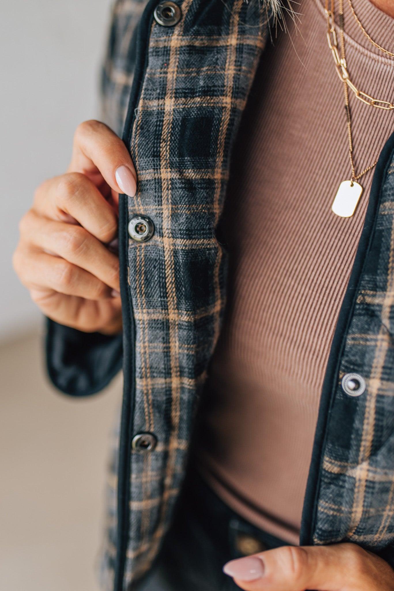 Person wearing a plaid jacket with a neutral background