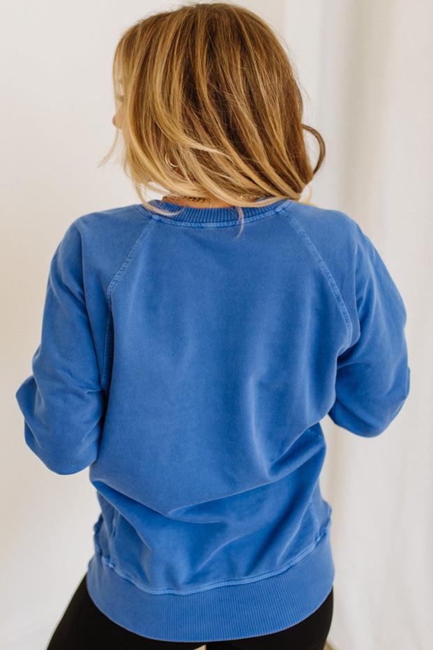 Person wearing a blue sweatshirt from behind on a plain background