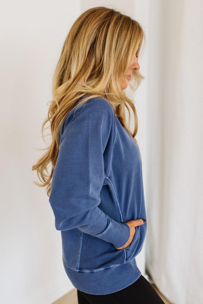 Woman wearing a blue pullover against a white background