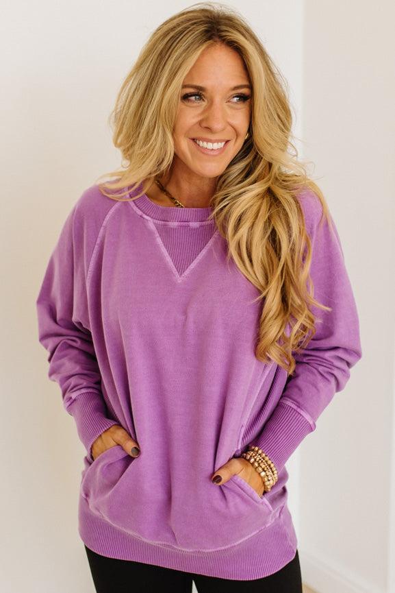 Woman wearing a purple sweater with a plain background