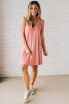 Blonde woman wearing a knee length ribbed kit dress.