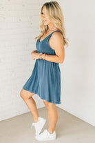 Blonde woman wearing a knee length ribbed kit dress.