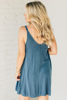 Blonde woman wearing a knee length ribbed kit dress.