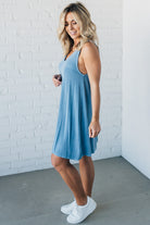 Blonde woman wearing a knee length ribbed kit dress.