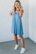 Blonde woman wearing a knee length ribbed kit dress.