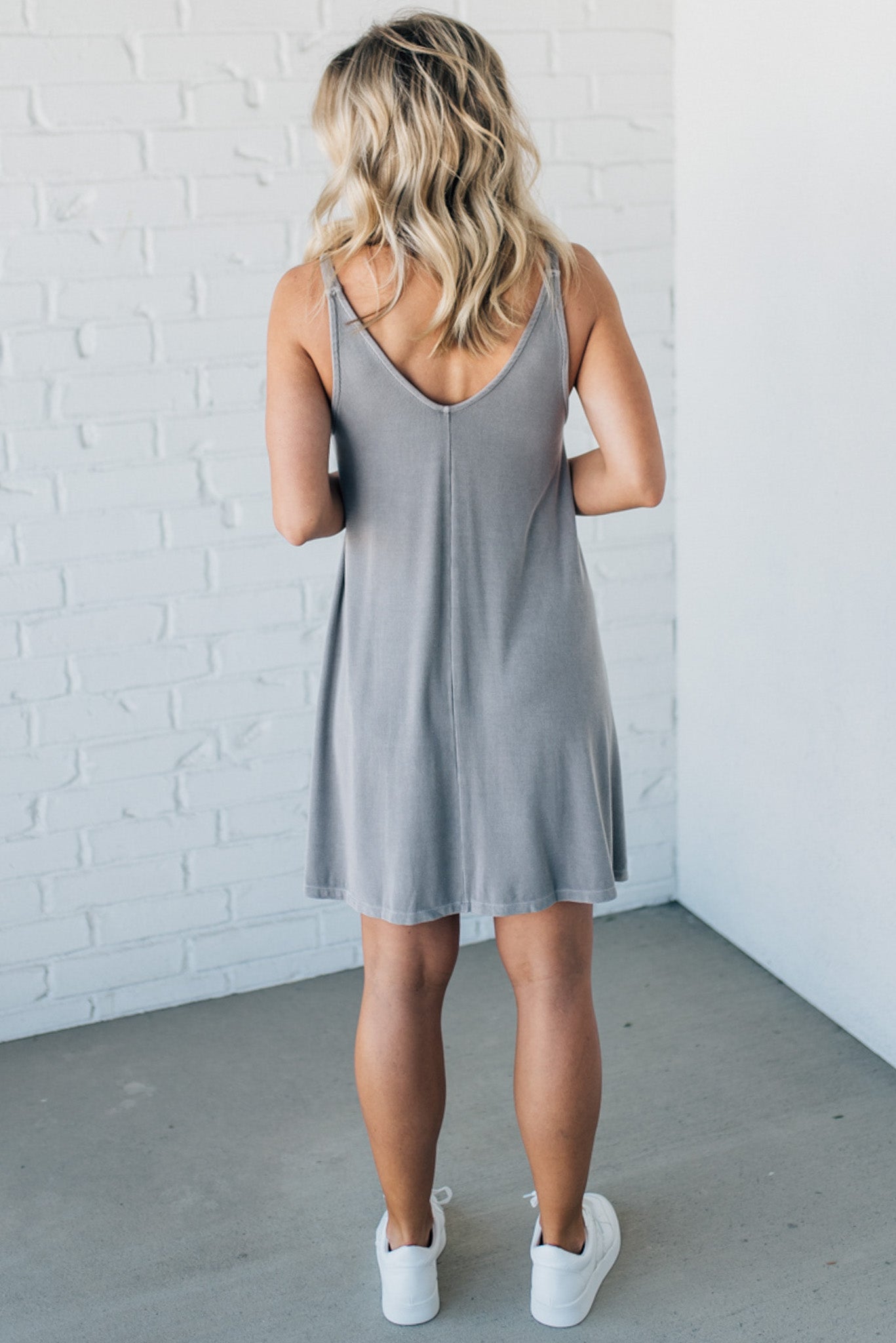 Blonde woman wearing a knee length ribbed kit dress.