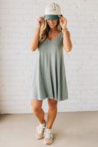 Blonde woman wearing a knee length ribbed kit dress.