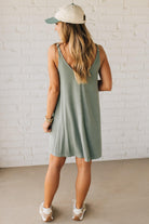 Blonde woman wearing a knee length ribbed kit dress.