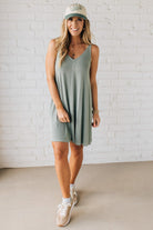 Blonde woman wearing a knee length ribbed kit dress.